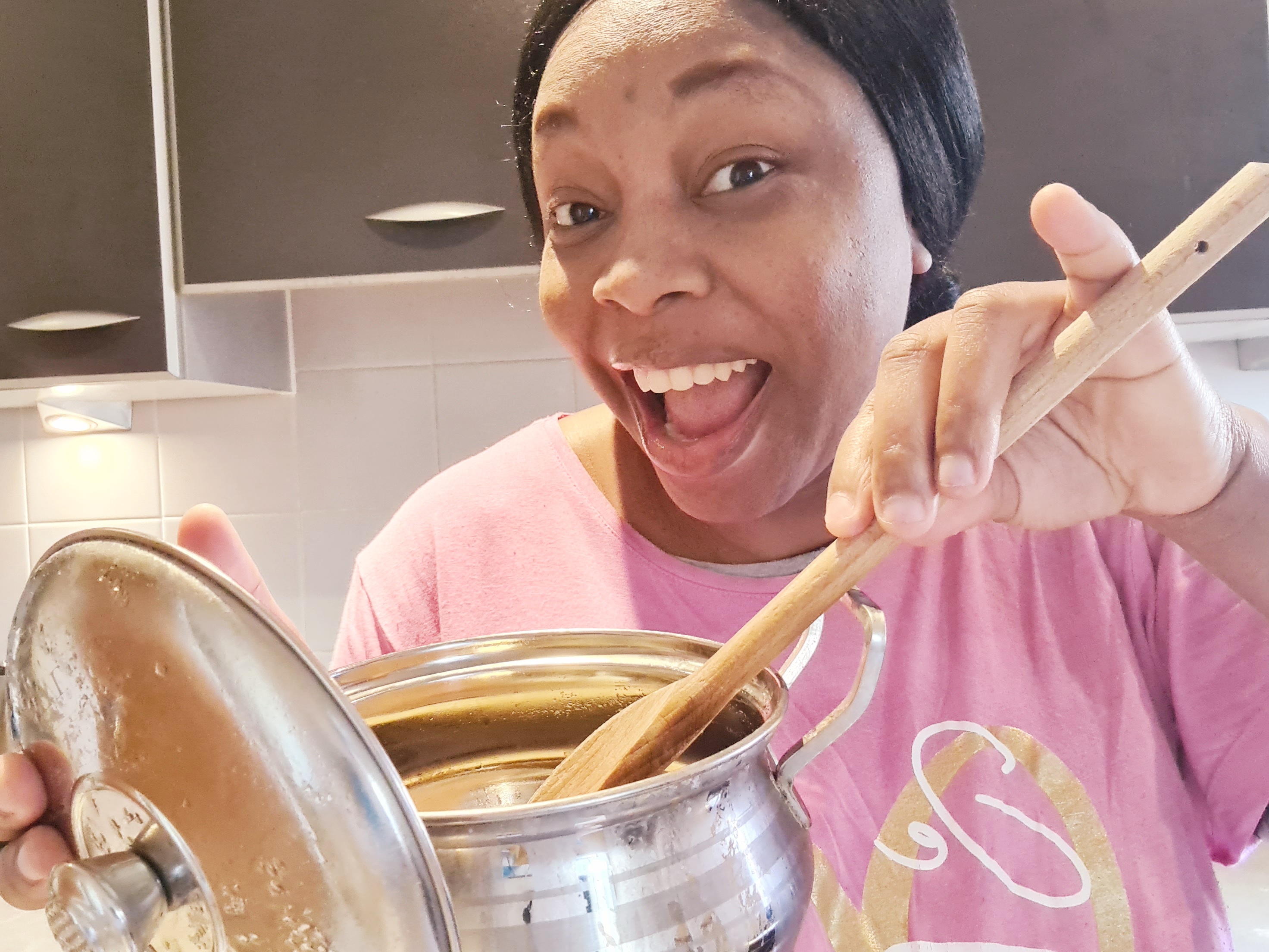 Adebimpe in the kitchen, holding a cooking pot